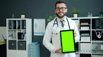 Doctor holding a tablet with a green screen.