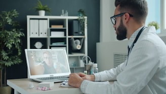 Doctor consulting patient via video call on laptop.