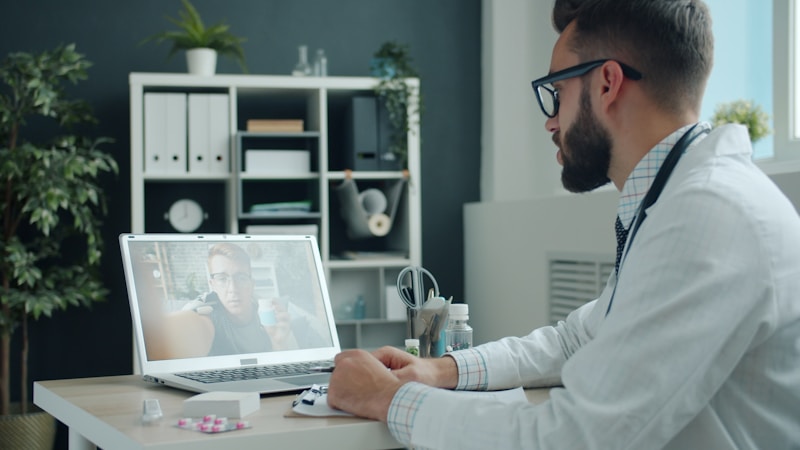 Doctor consulting a patient via video call on a laptop