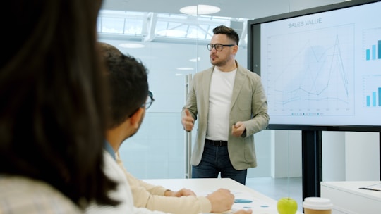 Winnipeg business person presenting data on a large screen to colleagues.