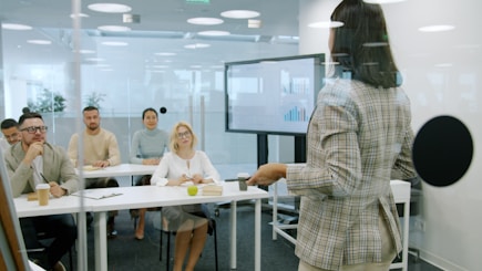 Woman presenting to an attentive audience in a modern office.
