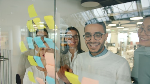 Diverse team brainstorms with colorful sticky notes.