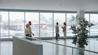 People in a modern office lobby with large windows