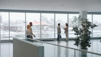 People in a modern office lobby with large windows