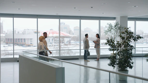 People in a modern office lobby with large windows
