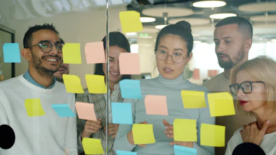 Team brainstorming with colorful sticky notes on glass.