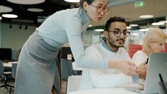 Two colleagues collaborating on a laptop in office.