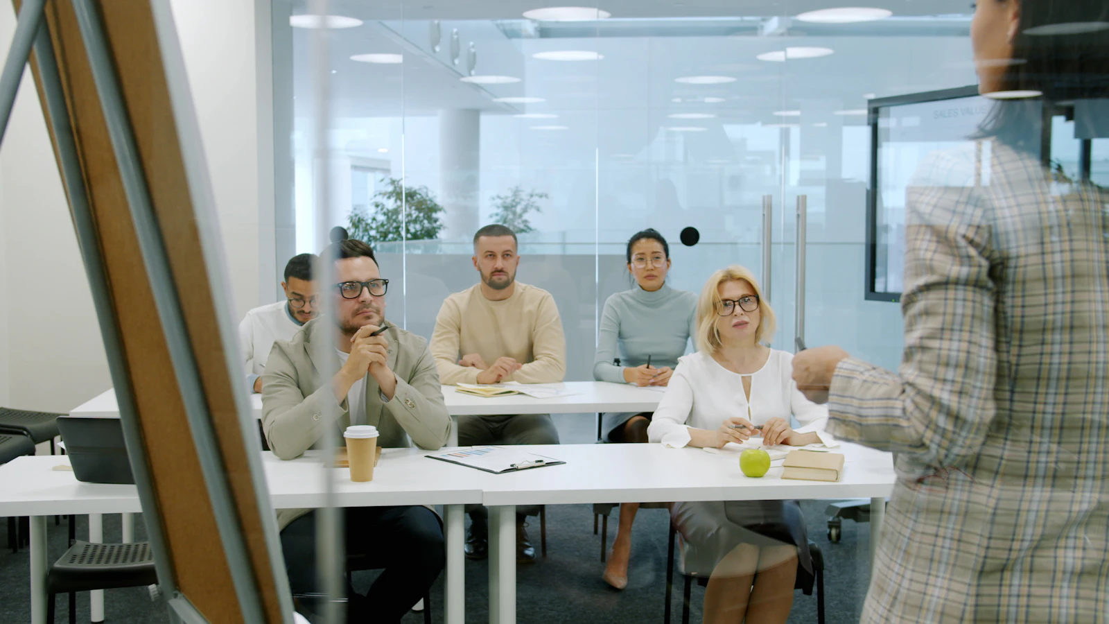 A business leader presenting to a collaborative team in a modern office