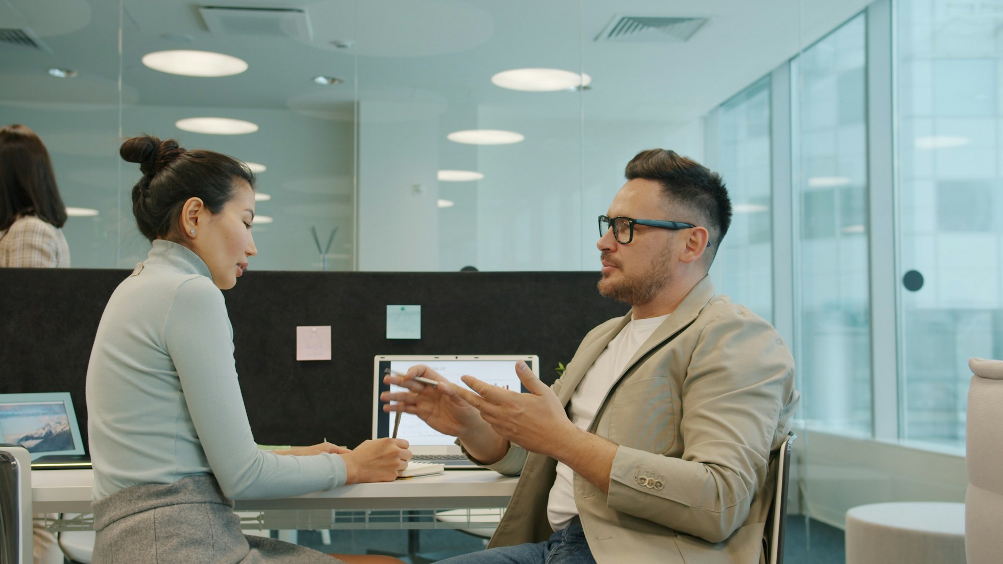 Two colleagues in conversation in a calm modern office
