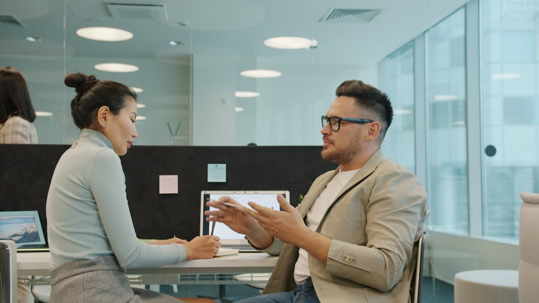 Two colleagues discussing financial plans in a modern office
