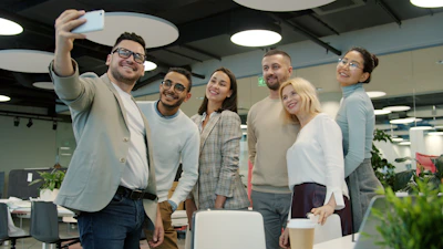 Colleagues taking a selfie in a modern office.