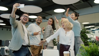 Diverse group of colleagues taking a selfie in office.