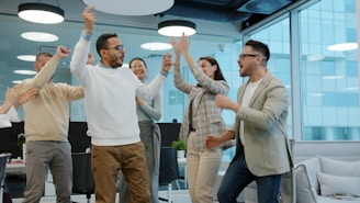 A diverse group of colleagues celebrating success in an office.