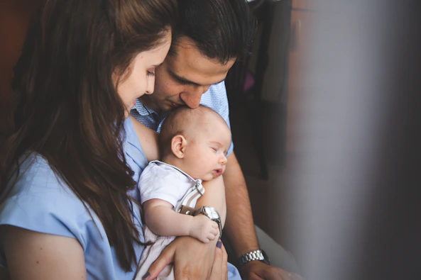 Parents holding their sleeping newborn baby