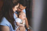 Parents holding their sleeping newborn baby
