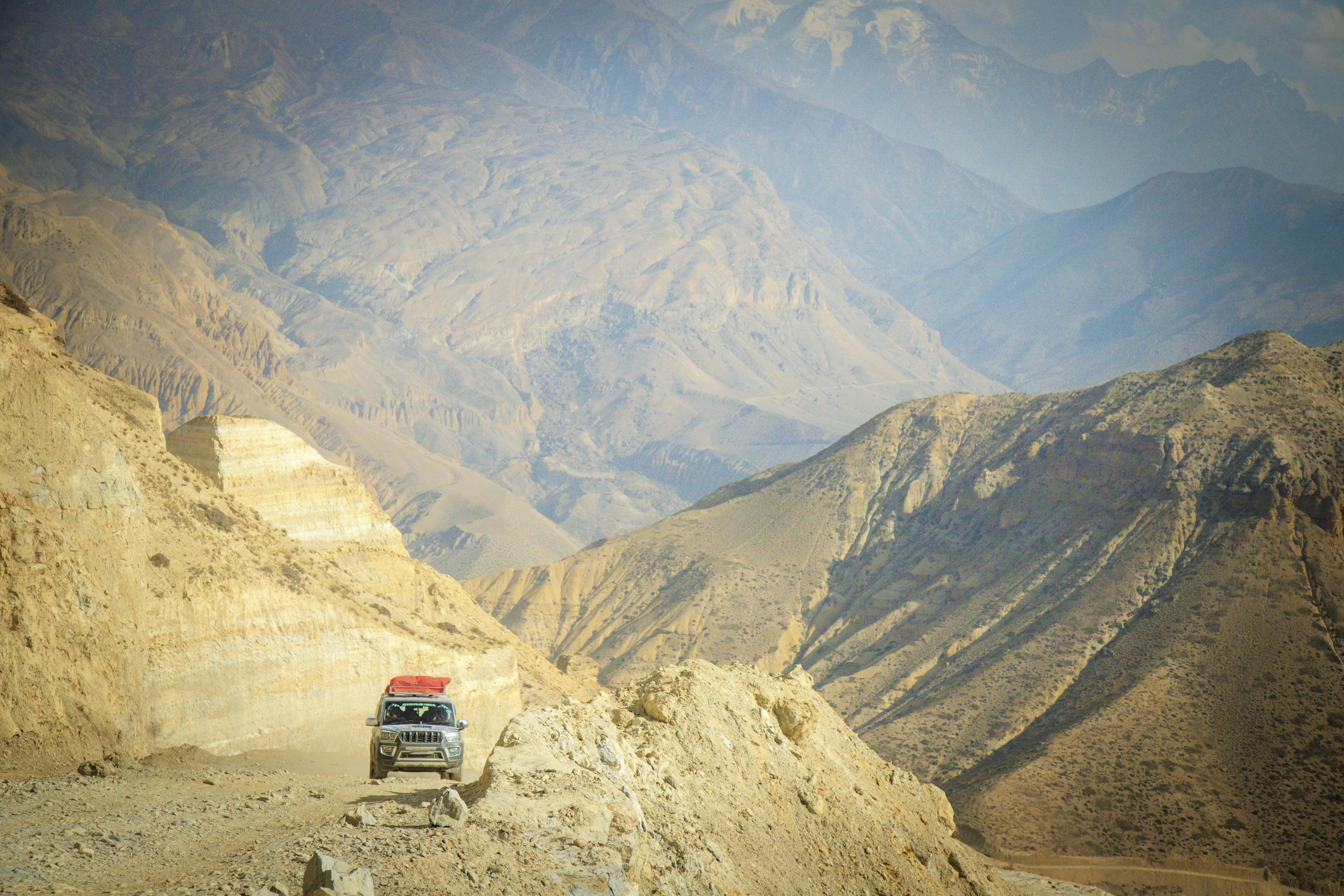 A truck navigates a narrow mountain road.