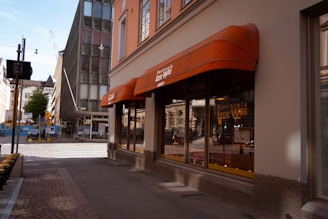 Orange awnings over shop windows on a street.