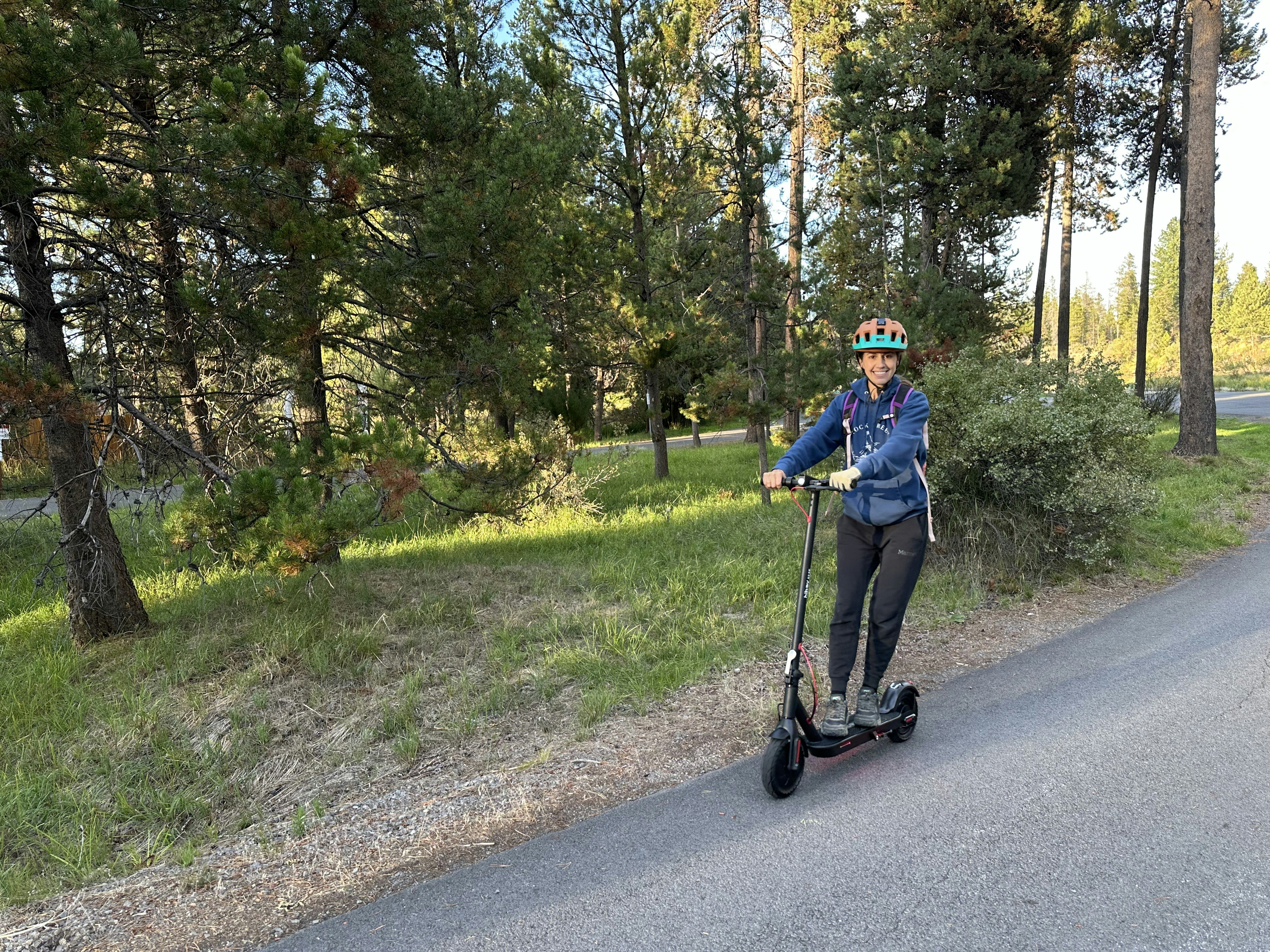 Woman riding an electric scooter on a paved path