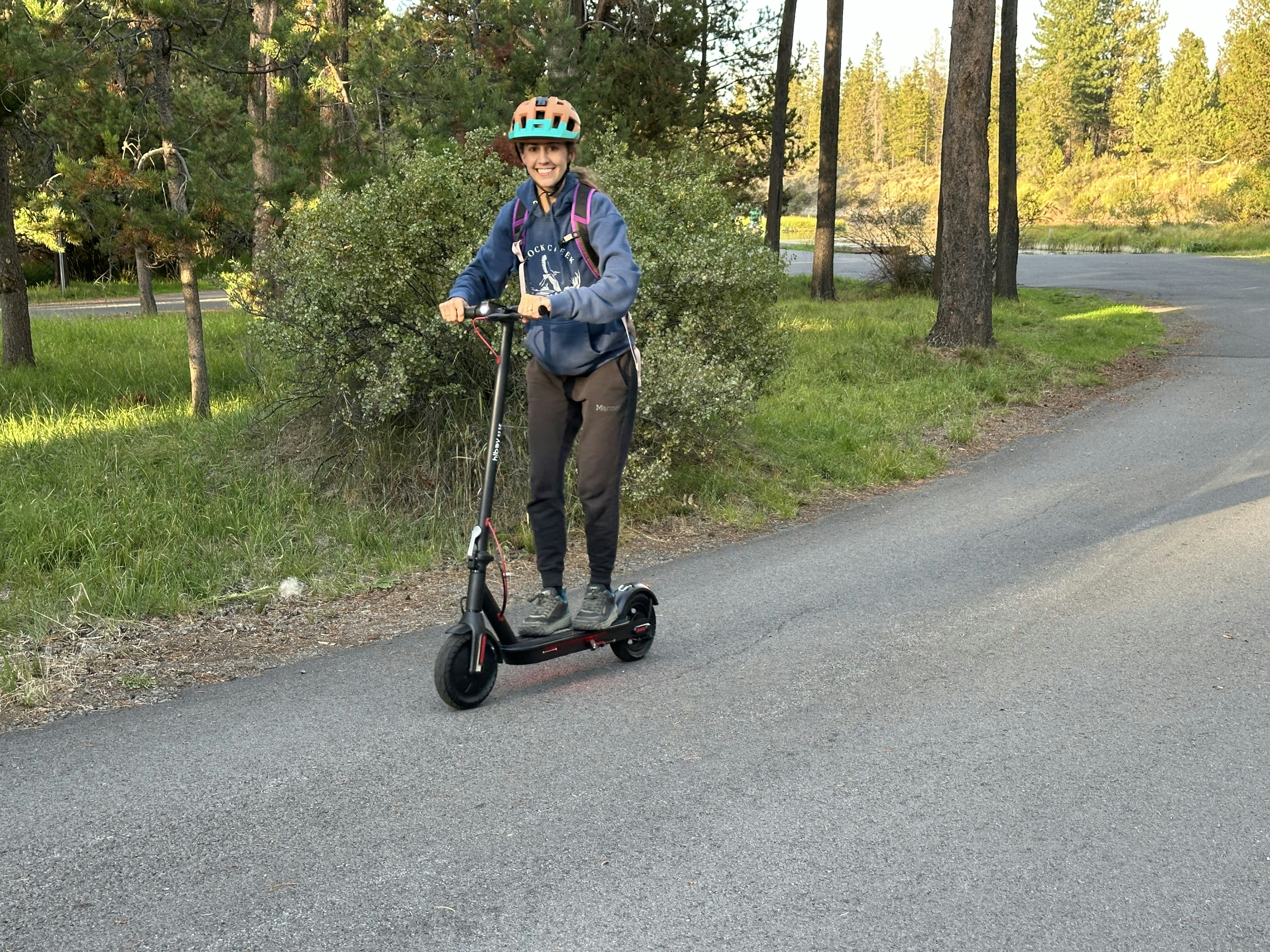 Woman riding an electric scooter on a paved path