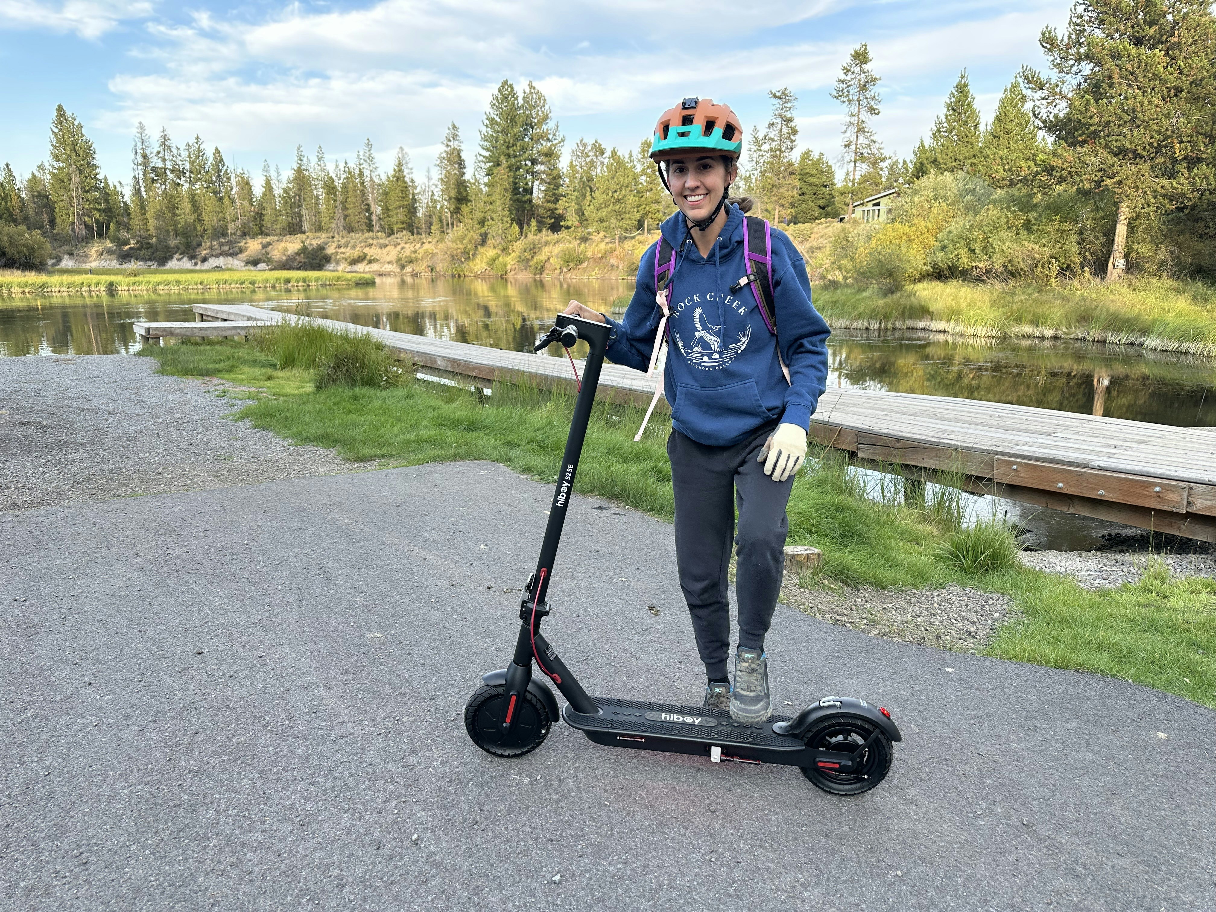 Person on electric scooter by lake