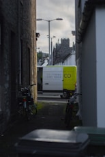 Delivery van parked in a narrow urban alleyway.