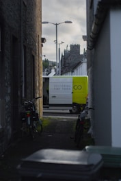 Delivery van parked in a narrow urban alleyway.