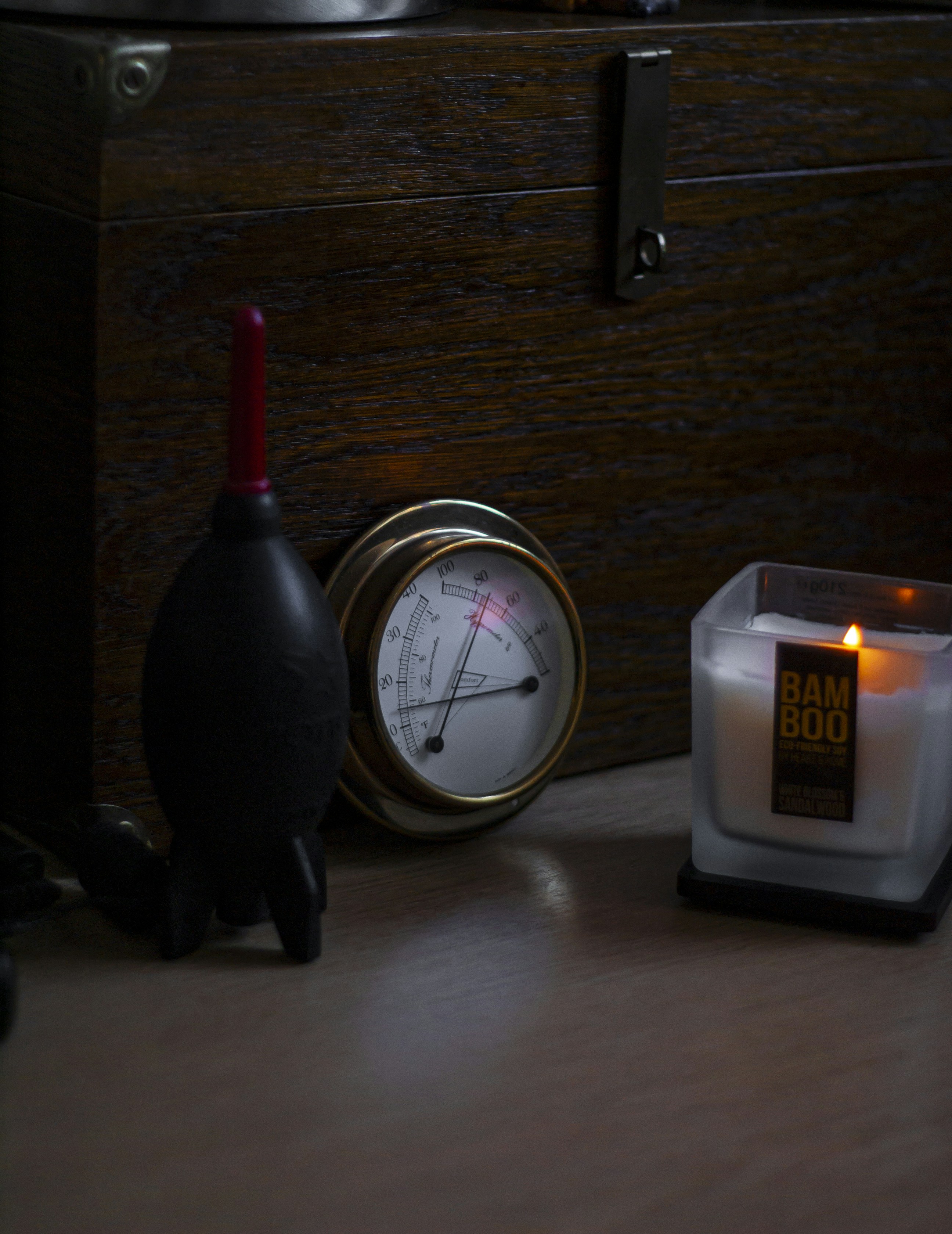 Candle, gauge, and blower on wooden surface