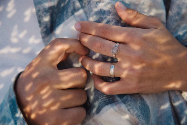 Manos entrelazadas mostrando los anillos de boda