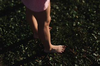 Bare feet walking on green grass