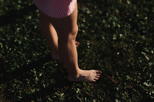 Bare feet walking on green grass