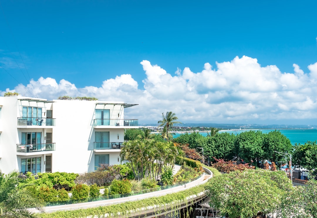 Modern white building overlooking tropical ocean and greenery