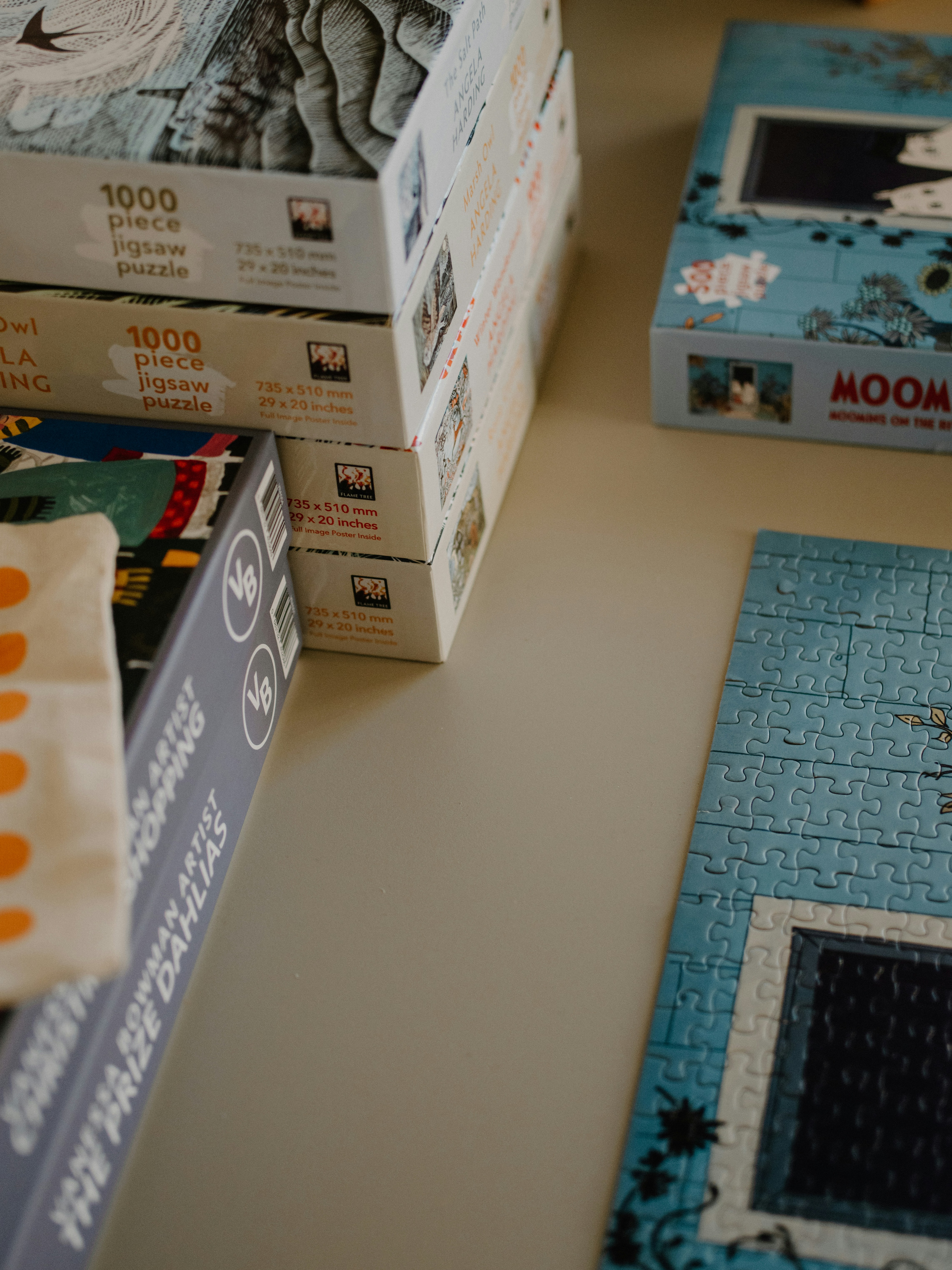 Several boxes of jigsaw puzzles stacked neatly.