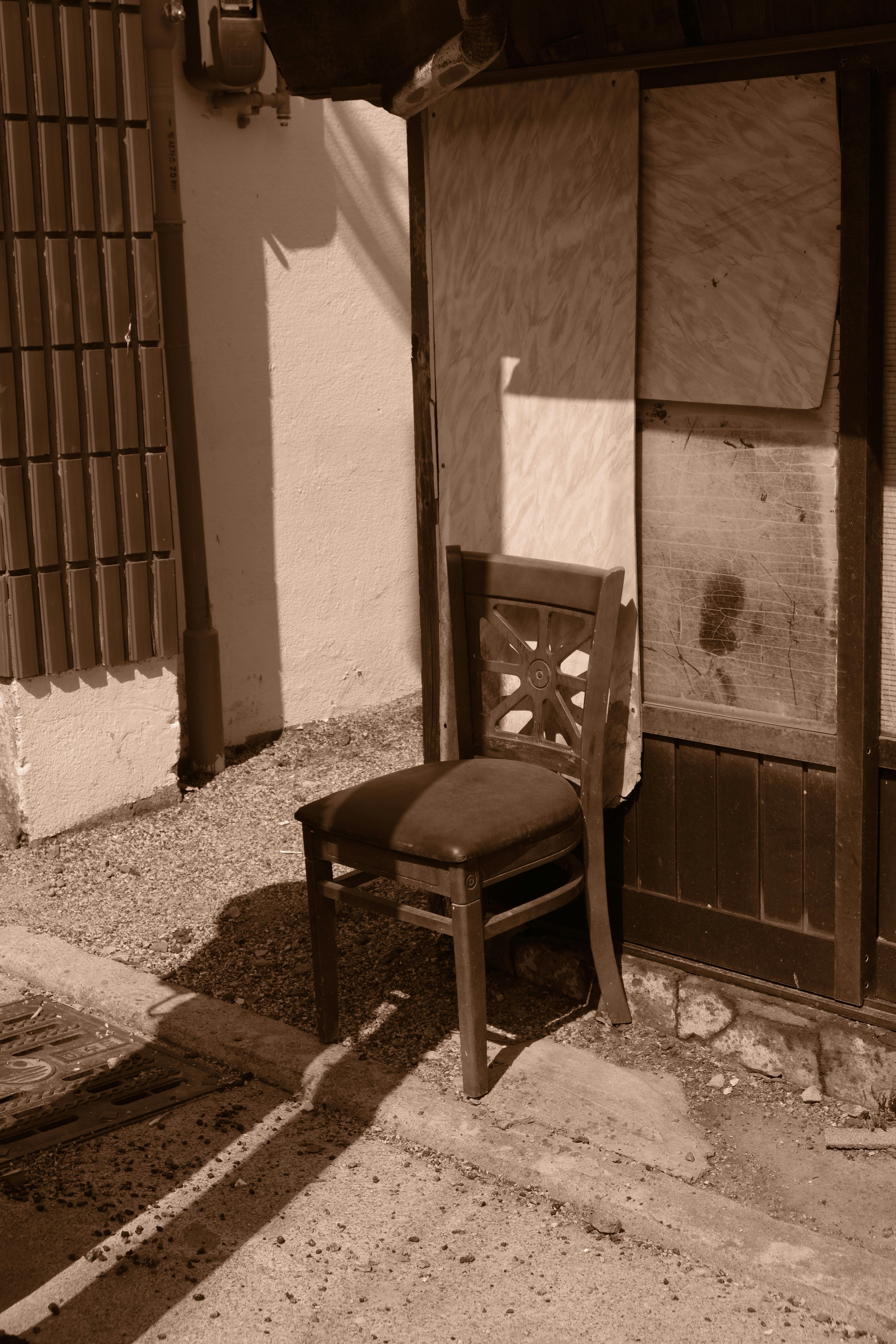 Uma cadeira de madeira fica do lado de fora de um prédio à noite.