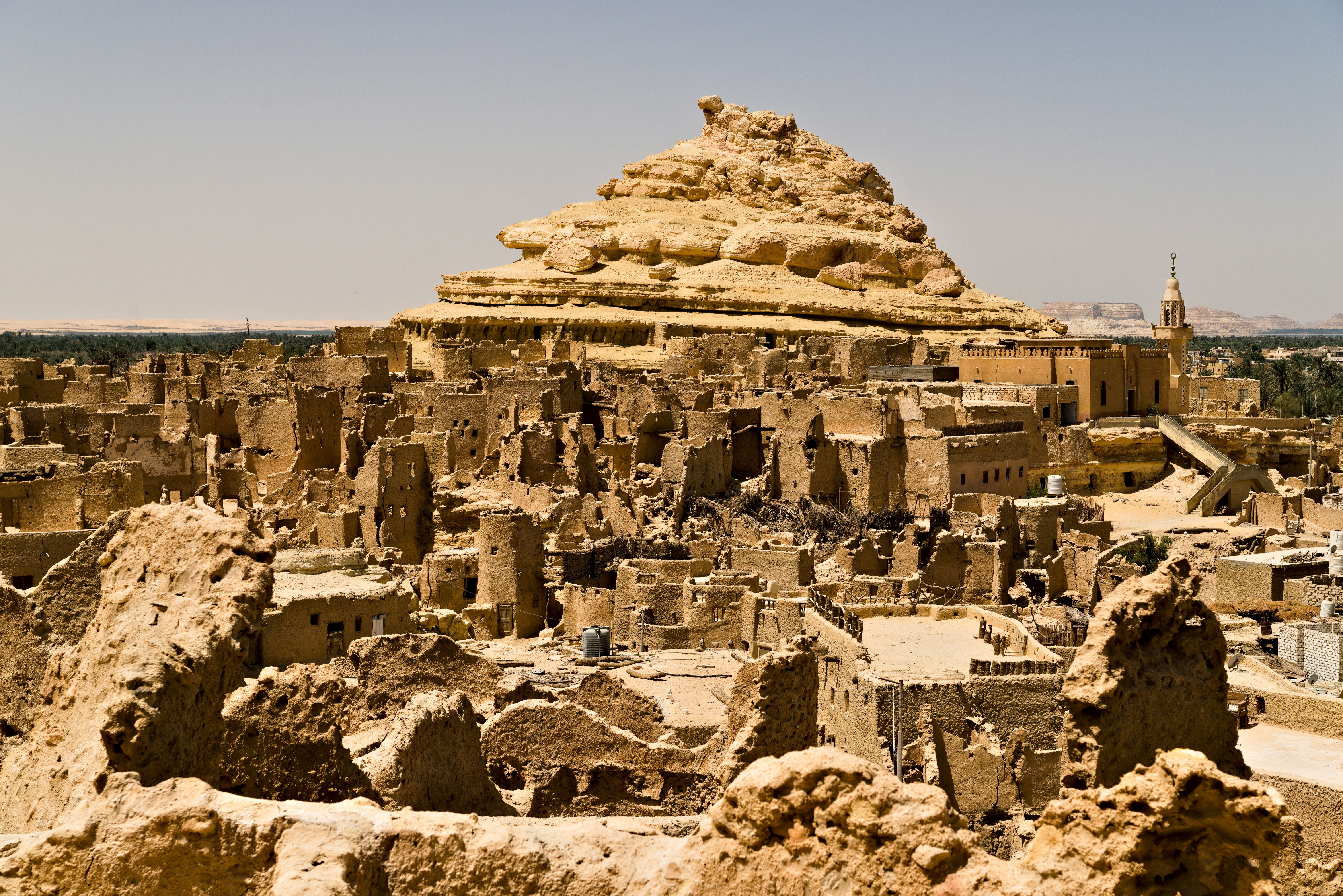 Ancient mud-brick village ruins under a clear sky