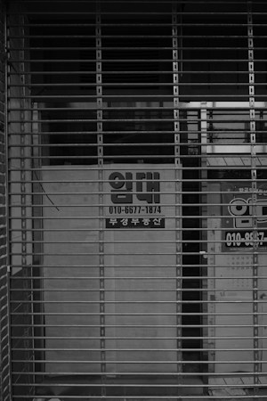 A closed storefront with a metal security gate pulled down, a reminder of what long uncertainty can do to small shops in an older retail center