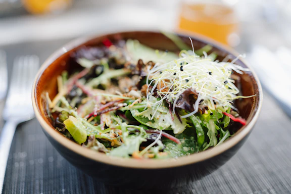 Fresh salad in a rustic bowl with sprouts