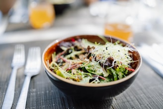 A fresh salad in a bowl on a wooden table.