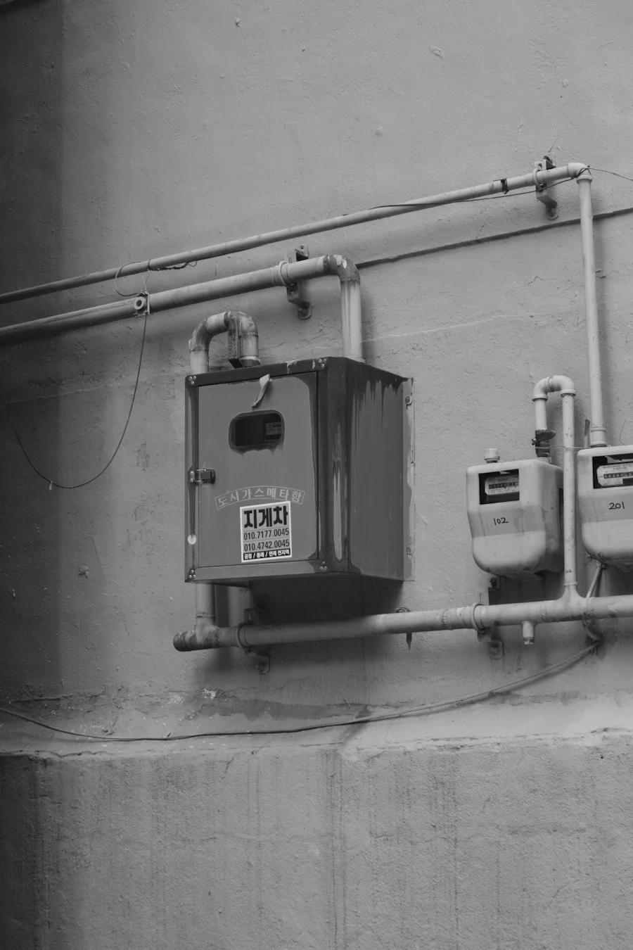 Residential gas meters and pipes on an exterior wall