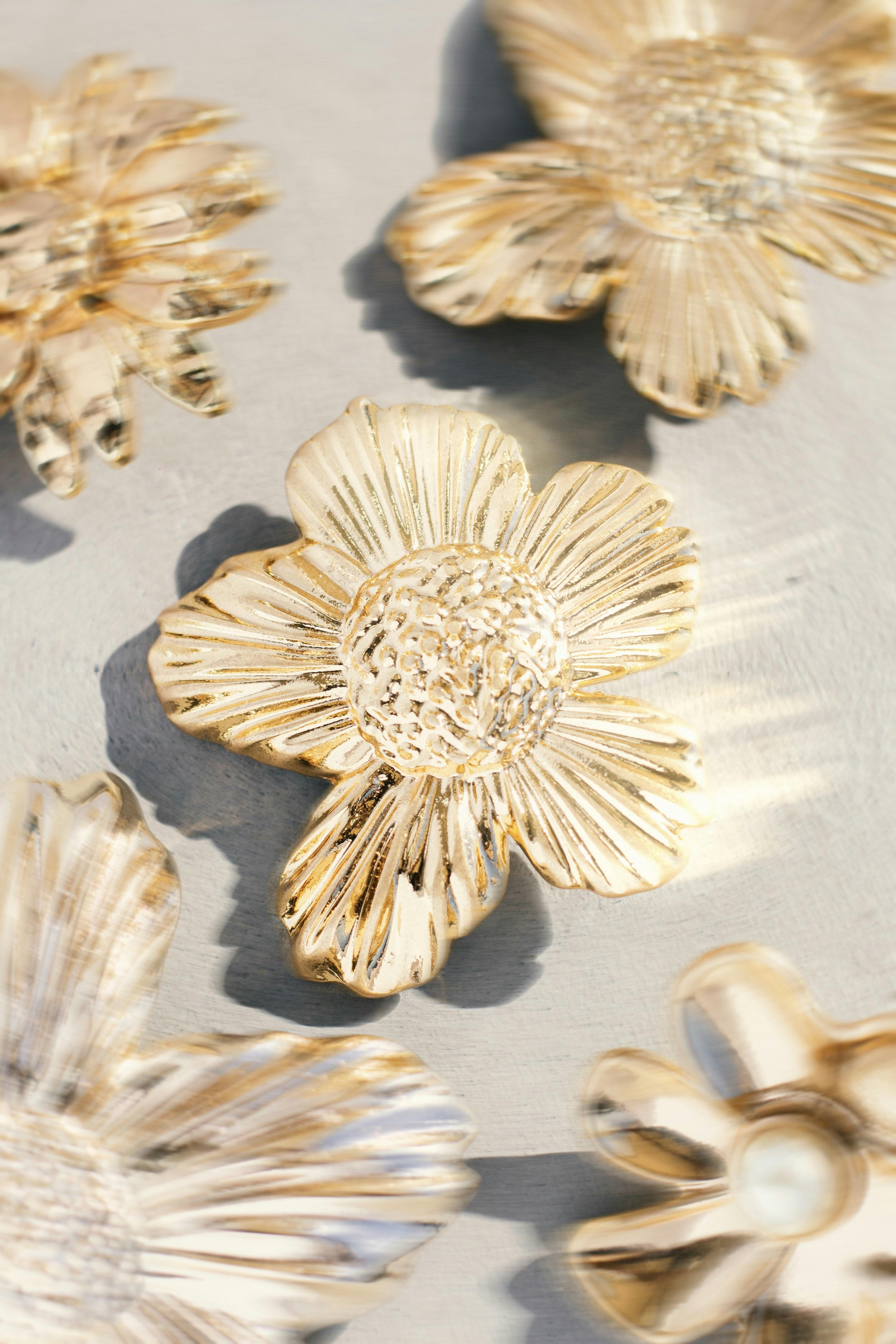 Several ornate golden flower ornaments on a grey surface photo – Free Flower  Image on Unsplash, image size:3000x4500
