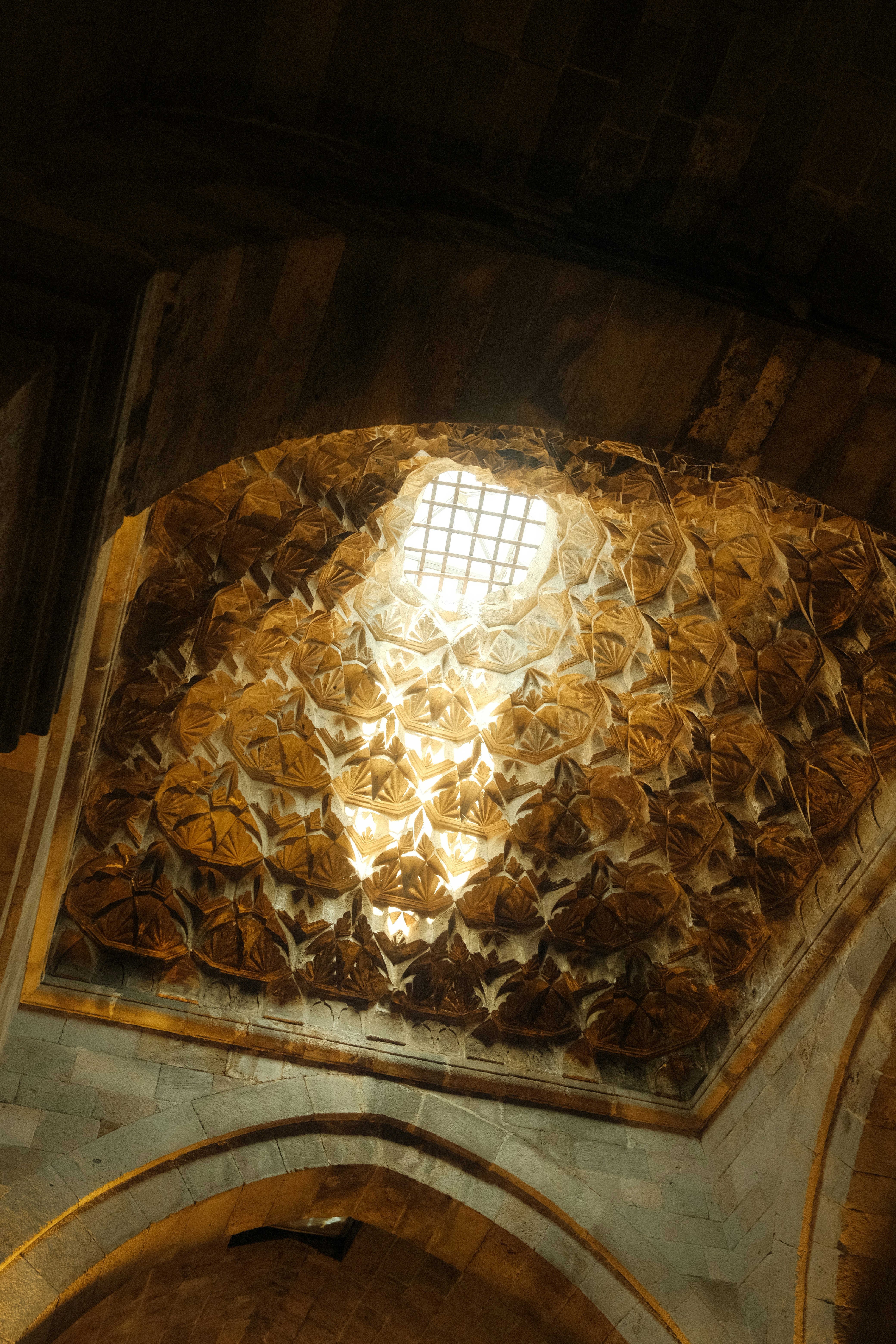 Intricate geometric patterns on an ancient stone ceiling.