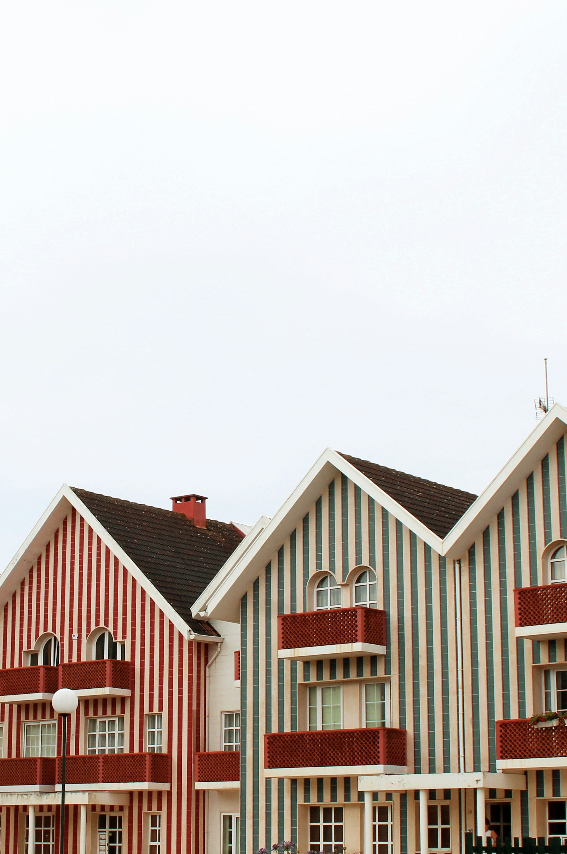 Maisons rayées colorées avec balcons sous un ciel nuageux