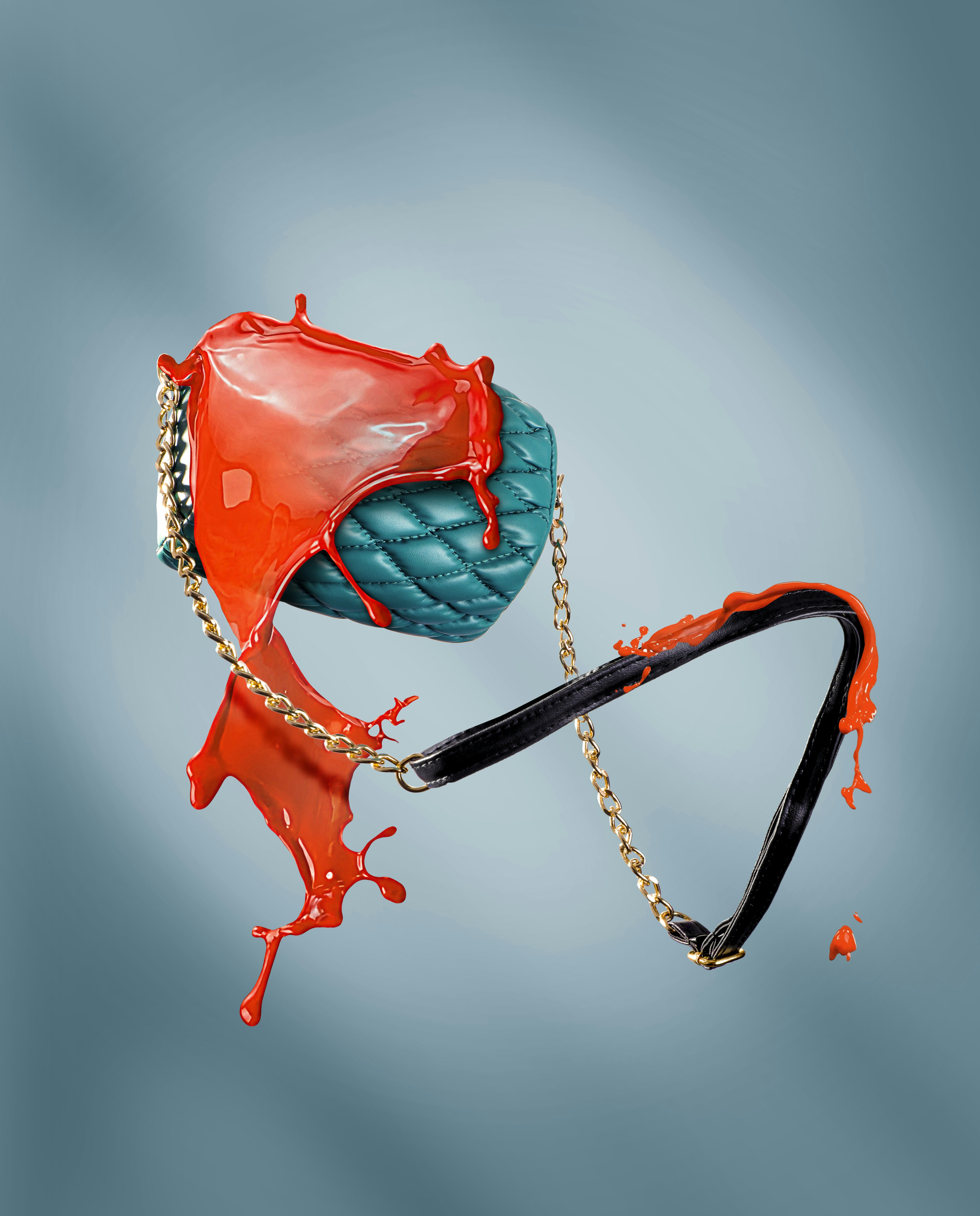 Teal handbag with orange paint splashing on it