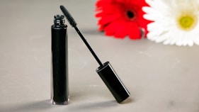 Black mascara tube and wand with flowers