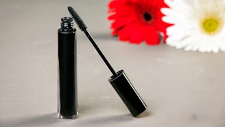 Black mascara tube and wand with flowers