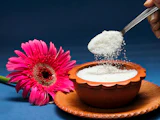 Sucre versé à la cuillère dans un bol