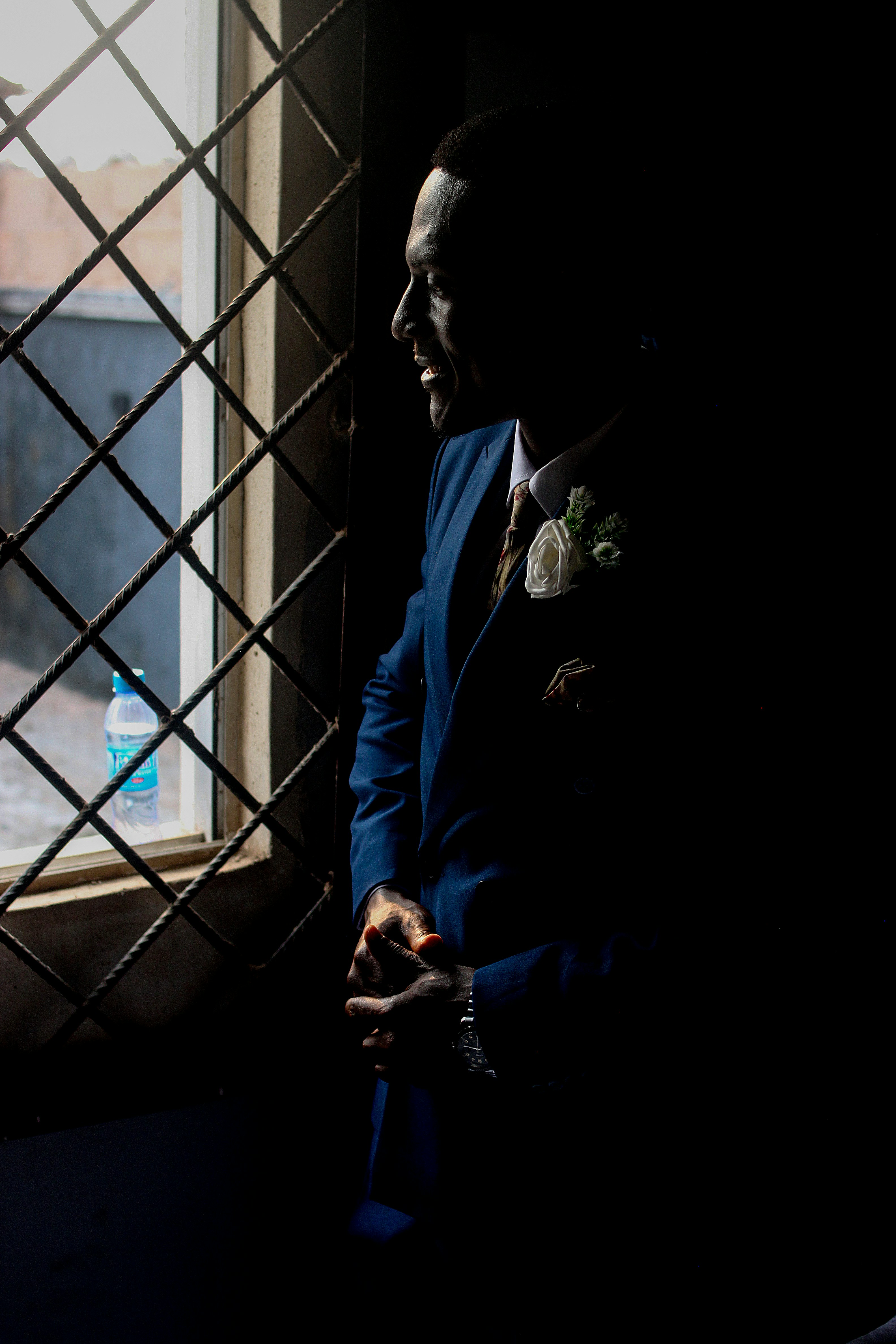 Homme en costume bleu regardant par une fenêtre