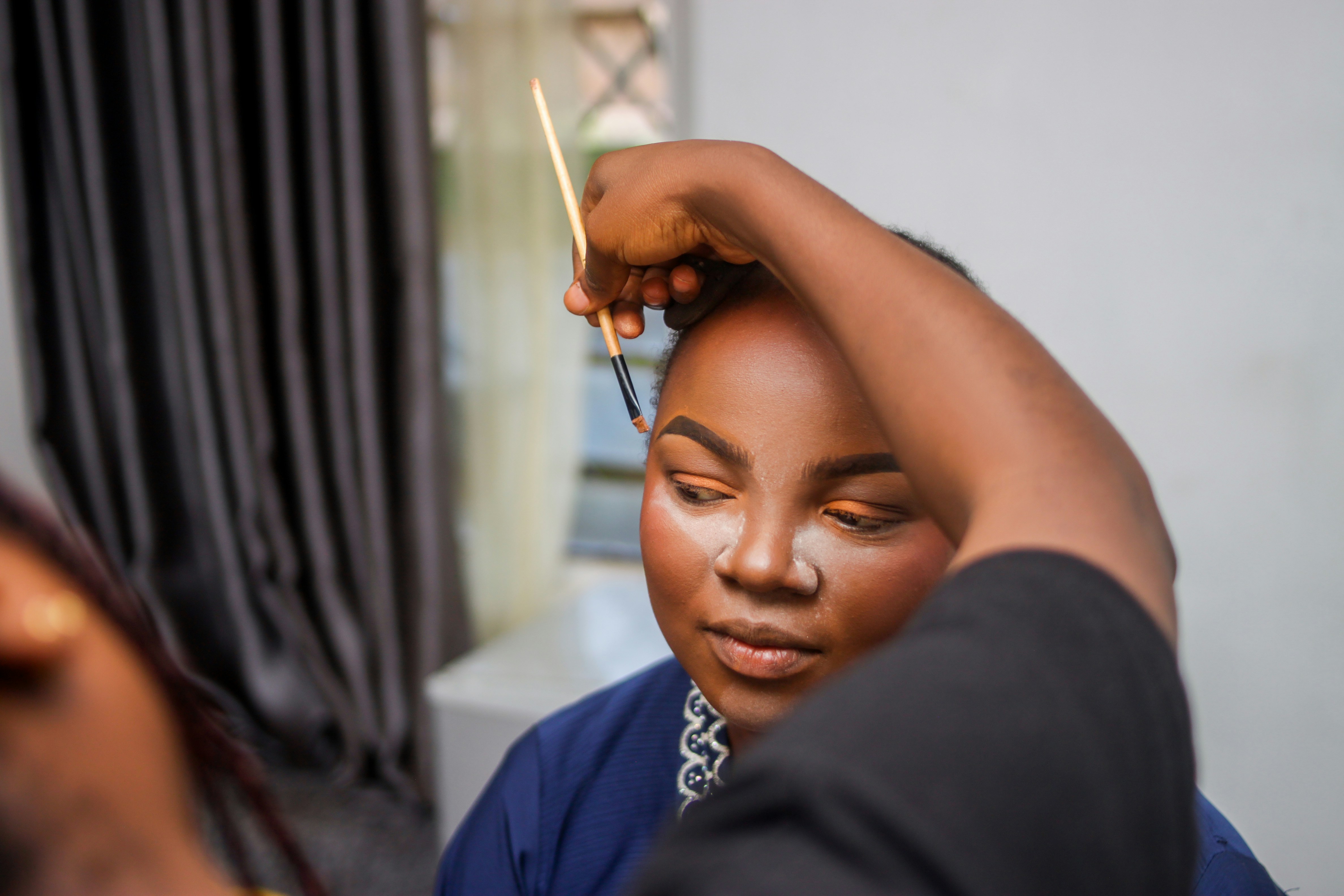 Makeup artist applying makeup to a woman's face.