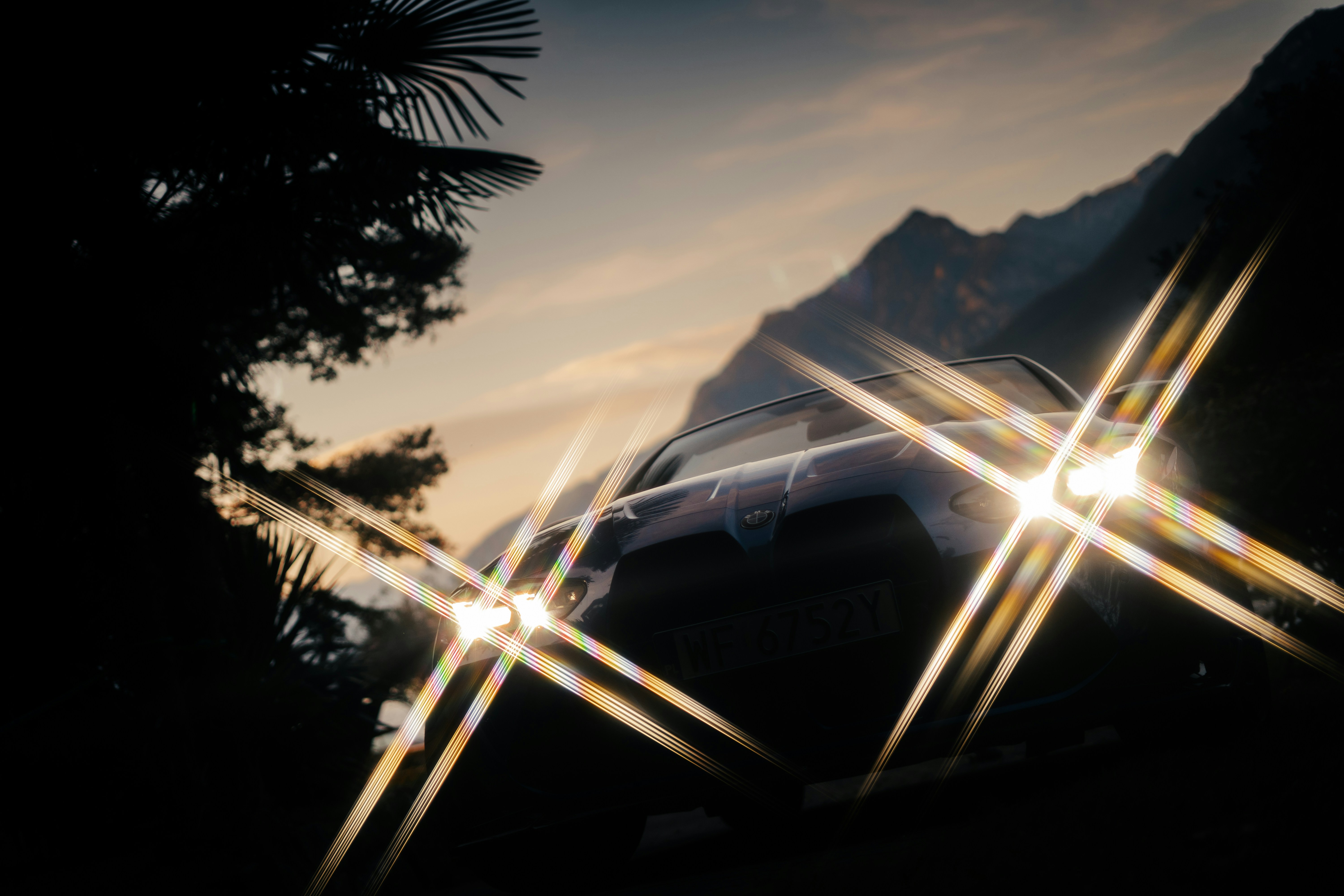 Sonneneruptionen über Bergen in der Abenddämmerung mit Bäumen