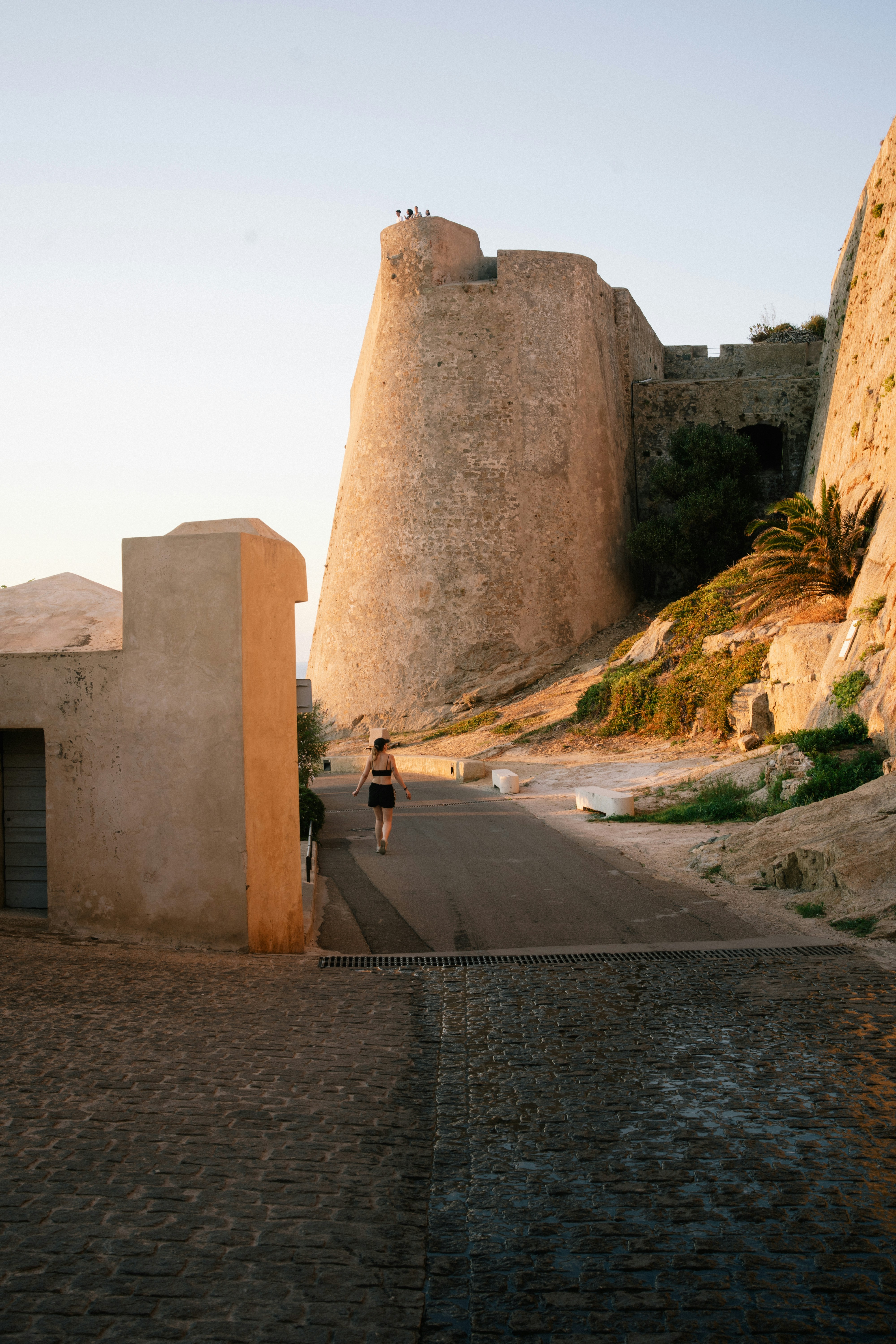 Die Person geht den Weg hinauf zur alten Steinfestung