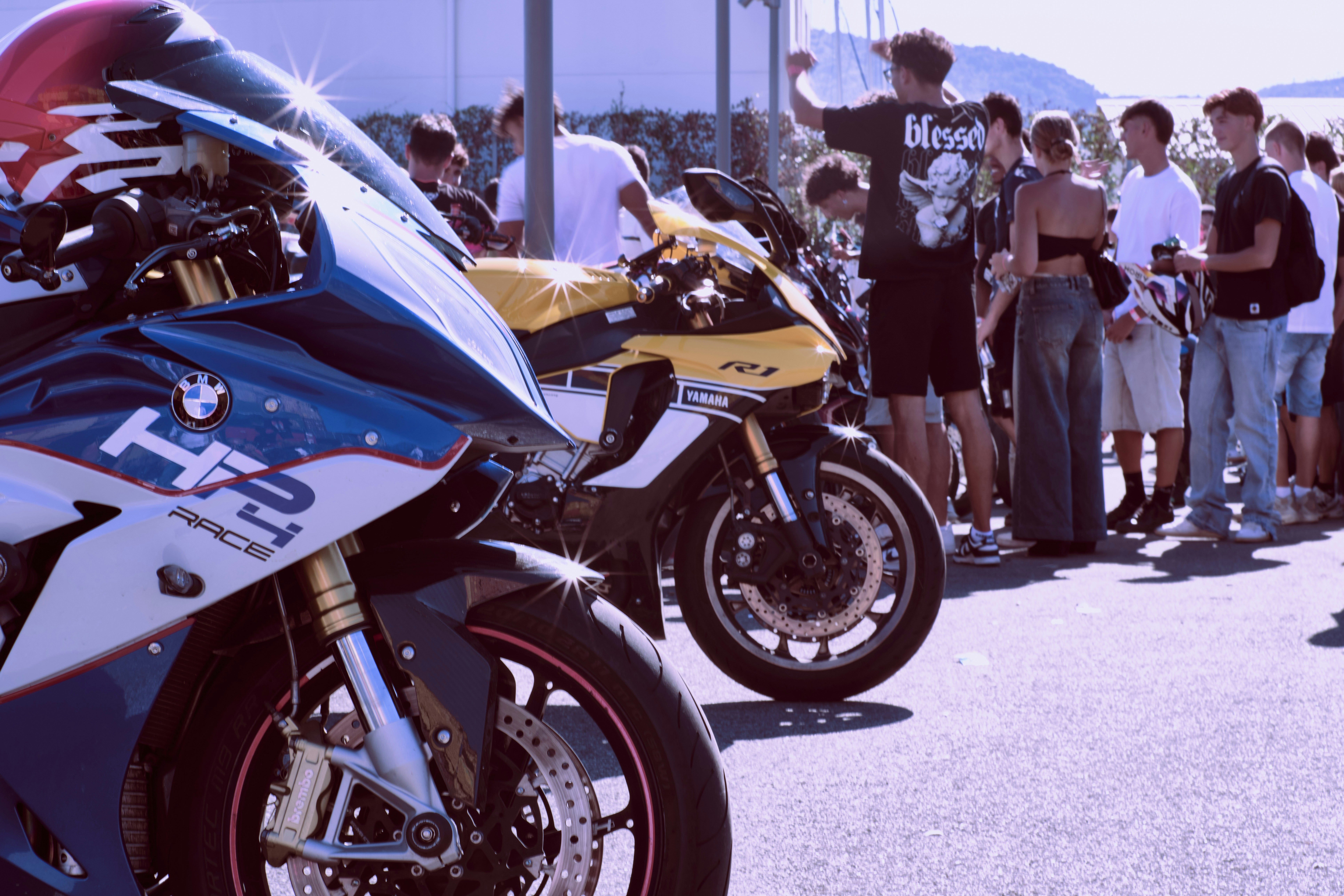 Motorcycles parked with a crowd of people watching